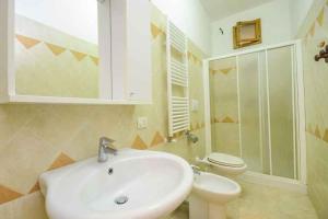 Apartment Sorrento 1 في سورينتو: حمام مع حوض أبيض ومرحاض