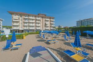 una playa con sillas y sombrillas y un hotel en Residence Zeta Immobiliare Pacella, en Lido di Jesolo