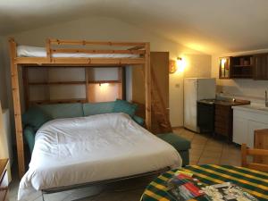 a bedroom with a bunk bed and a kitchen at Il Nido delle Rondini Balboutet in Usseaux