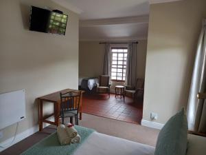 a living room with a bed and a table and chairs at 137 High Street Guest House in Grahamstown