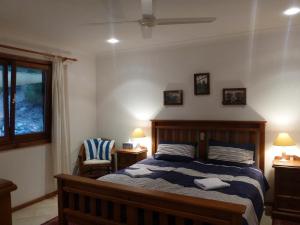 a bedroom with a bed and a chair and a window at Strandmarken in Island Beach