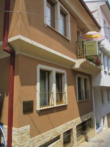 a building with a balcony and an umbrella at Apartments Stars in Ohrid