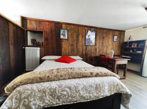 Un dormitorio con una cama con una almohada roja. en Chalet Saint Salod - Pila, en Charvensod