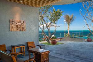 a patio with tables and chairs and a view of the ocean at Sala Grand Tuy Hoa Hotel in Tuy Hoa