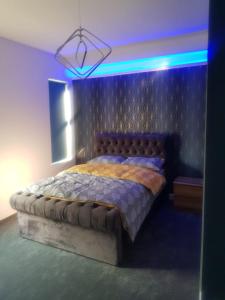 een slaapkamer met een kingsize bed met een blauw licht bij Highfields Living in Sheffield