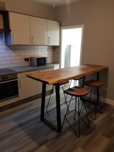 a wooden table in a kitchen with stools at Highfields Living in Sheffield
