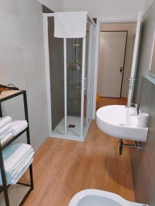W łazience znajduje się biała umywalka i prysznic. w obiekcie Ca' Palazzo w Mestre