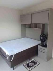 a small bedroom with a bed and a fan at Apto excelente à 50m do parque de águas termais in Piratuba