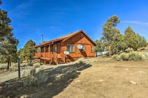 a wooden cabin in the middle of a field at Big Bear Lake Cabin with Deck and Views about 9 Mi to Ski! in Baldwin Lake