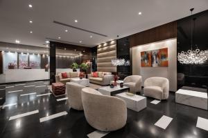 a living room with couches and chairs and a chandelier at Eurostars Das Letras in Lisbon