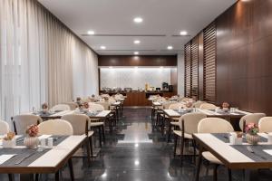 Un restaurante con mesas y sillas y un bar. en Eurostars Das Letras, en Lisboa