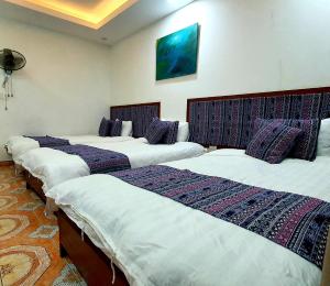 a row of four beds in a room at TRUC LAM HOTEL in Lao Cai