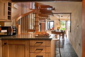 a kitchen with wooden cabinets and a spiral staircase at Finest Retreats - Dolwar Cottage in Tanygrisiau