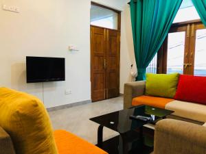 sala de estar con 2 sofás y TV en Hansons Homestay en Kandy