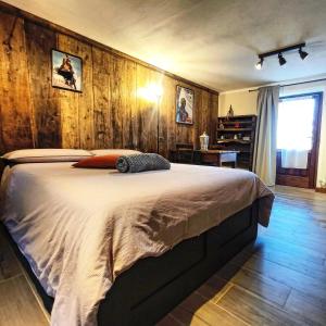 a bedroom with a bed and a wooden wall at Chalet Saint Salod - Pila in Charvensod
