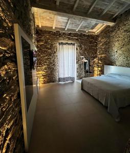 a bedroom with a bed and a stone wall at MP Luxury House in Budoni