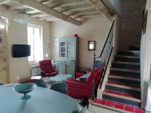 una sala de estar con sillas rojas y una escalera en Maison au bord de mer en Saintes-Maries-de-la-Mer