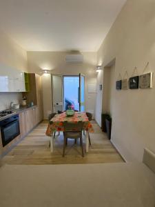 a kitchen and dining room with a table in a room at La maison del porto in San Foca