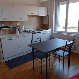 a kitchen with a table and chairs in a room at Appartement Calme Et Lumineux in Radinghem-en-Weppes