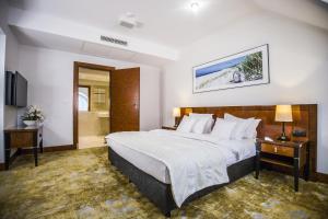 a hotel room with a large bed and a bathroom at Grand Lubicz Uzdrowisko Ustka in Ustka