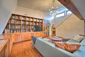 uma sala de estar com um sofá e uma televisão e estantes em Bohemian Home with Screened Porch, 3 Mi to Lake! em Stillwater