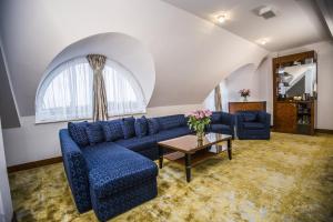 a living room with a blue couch and a table at Grand Lubicz Uzdrowisko Ustka in Ustka