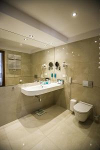 a bathroom with a sink and a toilet and a shower at Grand Lubicz Uzdrowisko Ustka in Ustka