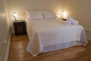 a bedroom with a white bed with two night stands at Hotel Boutique Casa Conde in Santiago
