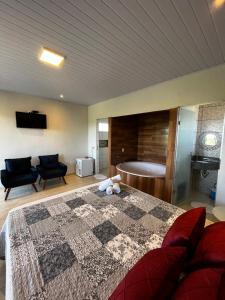 um quarto com uma cama e uma banheira num quarto em Pousada Encanto dos Anjos em Pirenópolis