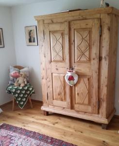 um grande armário de madeira num quarto com uma cadeira em Sunrise Retreat em Bad Blumau