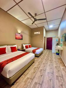 a hotel room with two beds and a ceiling fan at Sri Embun Resort Langkawi in Pantai Cenang