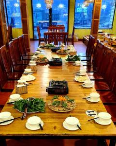 a long wooden table with plates of food on it at TRUC LAM HOTEL in Lao Cai