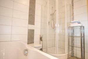 a white bathroom with a tub and a toilet at Almhaus Karantanien in Hochrindl +10 photos