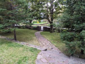 een stenen pad door een tuin met bomen bij Hill Road Manor Bed & Breakfast in Grand Falls -Windsor