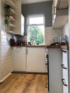 a kitchen with white cabinets and a window at Lovely 3 beds house 6 guests King beds in Sheffield