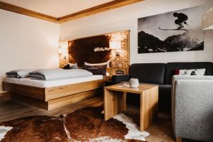 sypialnia z łóżkiem, kanapą i stołem w obiekcie Verwöhn-Wellnesshotel Walserhof w mieście Hirschegg