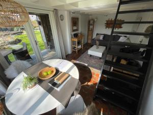 a living room with a table and a spiral staircase at Slapen op het platteland in Bodegraven