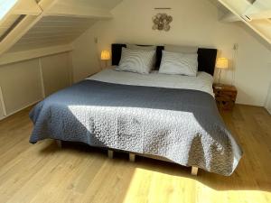 een slaapkamer met een bed met een grijs dekbed bij Slapen op het platteland in Bodegraven +36 foto's
