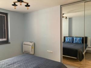 a bedroom with a mirror and a bed and a fan at Victor's Suite , with private parking in Varna City