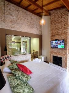 um quarto com uma cama grande e uma lareira em Pousada Bosque em Monte Verde