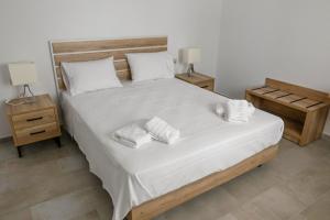 a bedroom with a large bed with two towels on it at Nissea Apartments in Naxos Chora