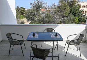 a blue table and four chairs on a balcony at Nissea Apartments in Naxos Chora