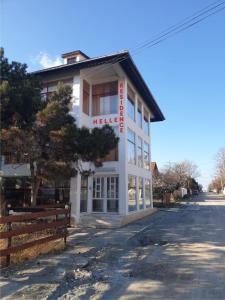 a white building with a red sign on it at Hellen Residence in Costinesti