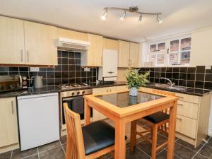 a large kitchen with a wooden table and chairs at Ickle Pickle Cottage in Thirsk
