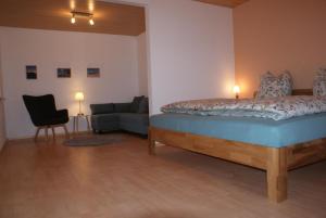 HofbieberにあるFerienwohnung Zum Kirschhofのベッドルーム1室(ベッド1台、ソファ、椅子付)