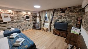 Soggiorno Madrid في فلورنسا: غرفة معيشة مع تلفزيون وجدار حجري