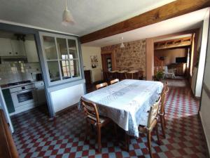 a kitchen with a table and some chairs and a table and a kitchen at Gîte Renaison, 4 pièces, 6 personnes - FR-1-496-257 in Renaison