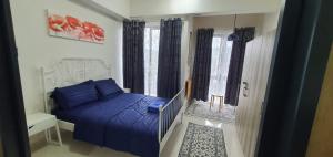 ein Schlafzimmer mit einem blauen Bett und einem Fenster in der Unterkunft Hannah suite at cameronfair in Cameron Highlands