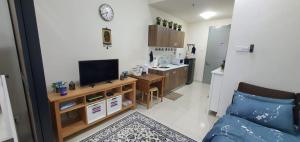 a living room with a couch and a tv and a kitchen at Hannah suite at cameronfair in Cameron Highlands