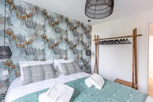 um quarto com uma cama com papel de parede floral em Sieck - Joli Appartement Vue mer em Carantec